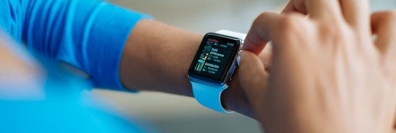 A woman playing with an apple smart watch.