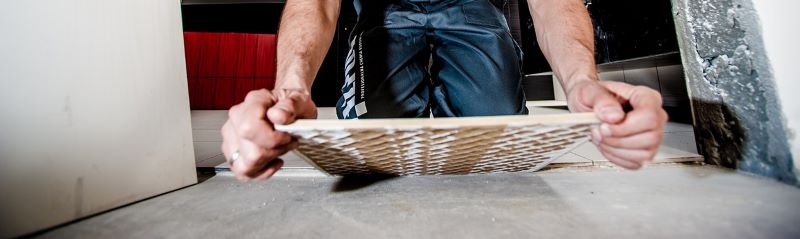 Laying tile cut with a wet saw.
