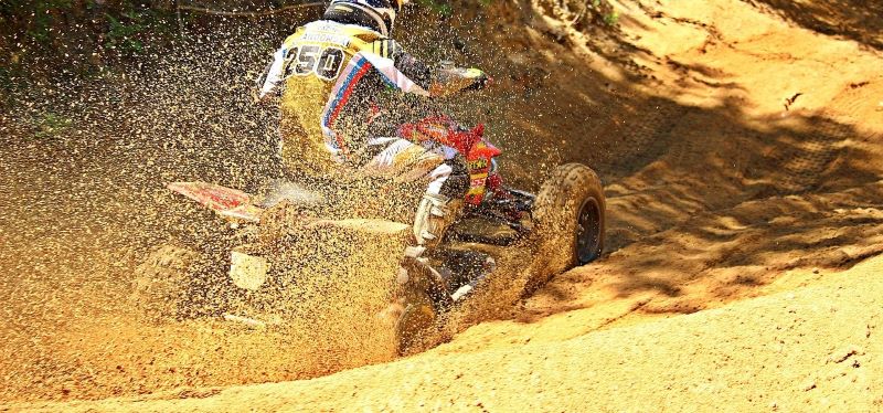 A yamaha ATV from financing playing in the mud.