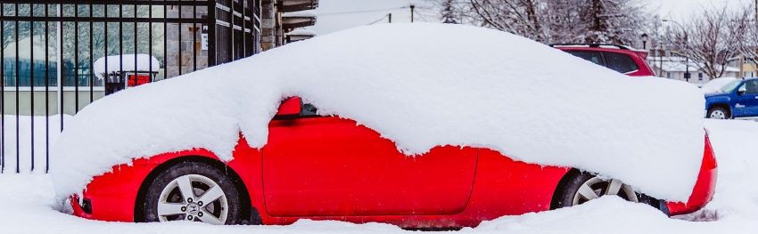 Snow on a car that needs a metal carport.